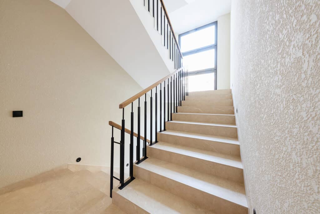 new stylish tile stairs with black metal railings in the house